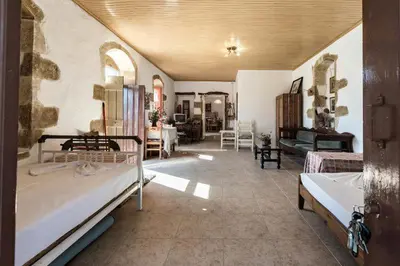 a room with two beds and a living room at Tsikalaria Traditional Stone House in Tsikalariá