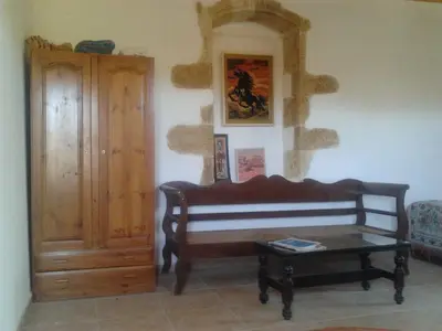 a living room with a bench and a table at Tsikalaria Traditional Stone House in Tsikalariá