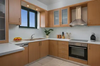 a kitchen with wooden cabinets and a sink at Villa Georgia Heated Pool & Jet-Tub in Kolymvari