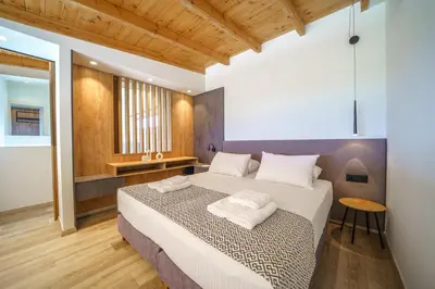 a bedroom with a large bed and a table at ISKIOS Premium in Agia Marina Nea Kydonias