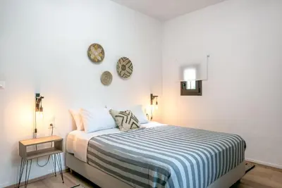 a bedroom with a bed with a blue and white striped blanket at Joel Living Collection - Rustic Villa in Áptera