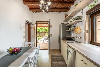 a kitchen with a large counter and a dining table at Joel Living Collection - Rustic Villa in Áptera