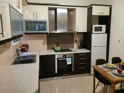 a kitchen with white appliances and a table with a dining room at Comfy APT in Chania City Center in Chania Town