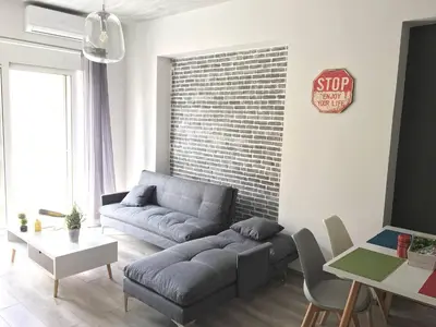 a living room with a couch and a stop sign on a brick wall at Pegasus Amazing Flat, 1,5min Walk To The Beach in Chania Town