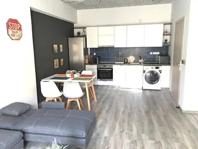a kitchen with a couch and a table in a room at Pegasus Amazing Flat, 1,5min Walk To The Beach in Chania Town