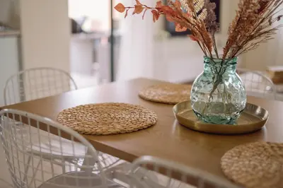a table with plates and a vase with flowers in it at Helen Sweet Home in Kounoupidhianá