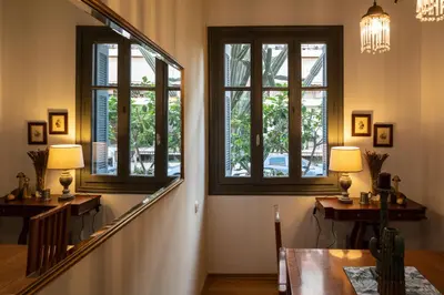 a hallway with two windows and a table and a staircase at Cactus Residence Chania in Chania Town