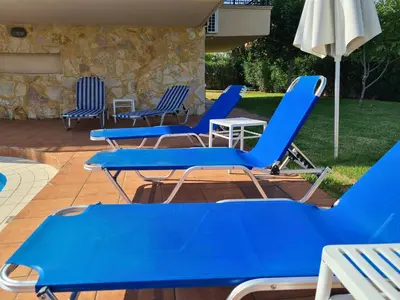 a group of blue chairs and an umbrella on a patio at VILLA PAGONI Residence Selini Villas N 1 Kolymbari Chania in Kolymvari