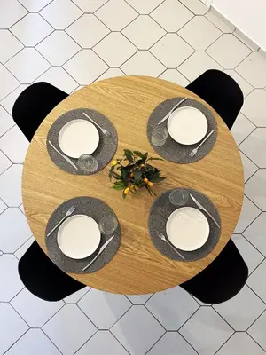a round wooden table with plates and hats on it at Anna's Apartment in Kato Daratso