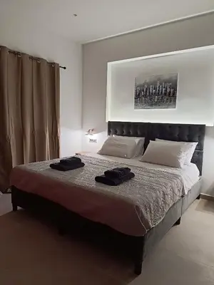 a bedroom with a bed with two black towels on it at Vrachakia Stylish in Ayiá