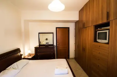 a bedroom with a bed with a television and a dresser at Electra's House in Chania Town