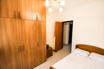 a bedroom with a bed and wooden cabinets at Electra's House in Chania Town