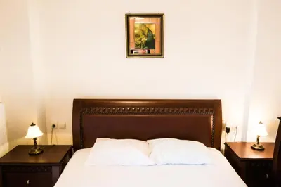 a bedroom with a bed with two night stands and a picture on the wall at Electra's House in Chania Town