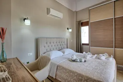 a bedroom with a white bed with a table and chairs at Villa Kostantina by PosarelliVillas in Plaka