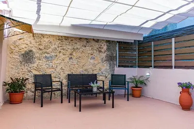 a patio with four chairs and a table and a wall at Traditional Mansion in Kaláthenai