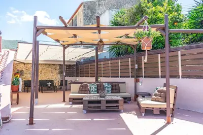 a patio with a yellow umbrella and chairs and a table at Traditional Mansion in Kaláthenai