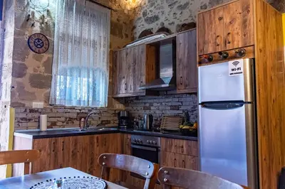 a kitchen with wooden cabinets and a white refrigerator at Traditional Mansion in Kaláthenai
