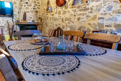 a wooden table with plates and glasses on it at Traditional Mansion in Kaláthenai