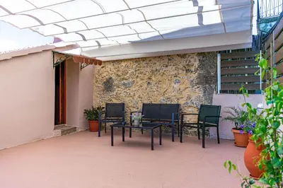 a patio with chairs and a table and a stone wall at Traditional Mansion in Kaláthenai