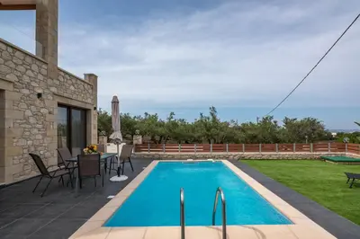 a swimming pool in a yard with a table and chairs at Lithina charm villa with private pool and sea view in Kamisianá