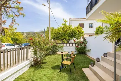 a small garden with a table and chairs on the grass at Stefanos apartment Chania in Chania Town