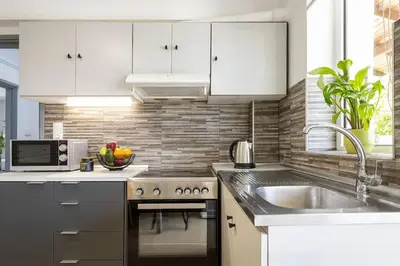 a kitchen with white cabinets and a sink at Stefanos apartment Chania in Chania Town