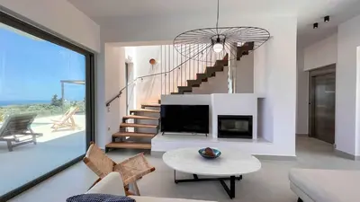 a living room with a fireplace and a staircase at Star Luxury Villa - Private pool, gym, playground in Kato Daratso
