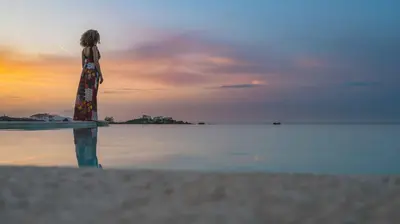 a woman standing on the beach looking at the water at Star Luxury Villa - Private pool, gym, playground in Kato Daratso
