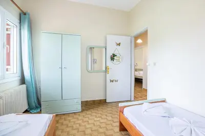 a bedroom with two beds and a mirror and a tub at Ortansia House near the Sea in Ayiá