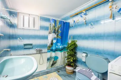 a blue bathroom with a toilet and a sink at Ortansia House near the Sea in Ayiá