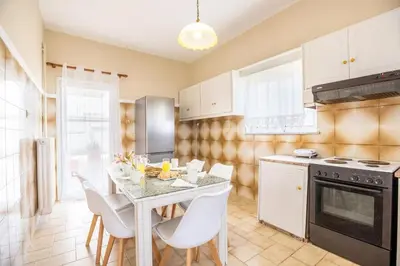 a kitchen with a table and chairs and a stove at Ortansia House near the Sea in Ayiá