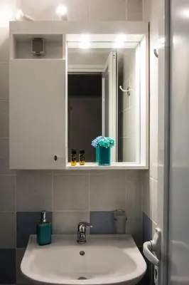 a bathroom sink with a mirror and a white cabinet at Zilina Homes2 in Chania Town