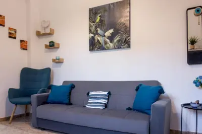 a living room with a couch and two blue chairs at Zilina Homes2 in Chania Town