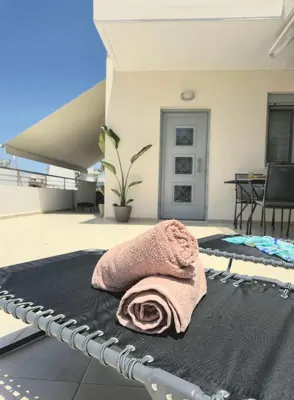 a towel laying on a bed on a patio at Idene Penthouse in Chania Town