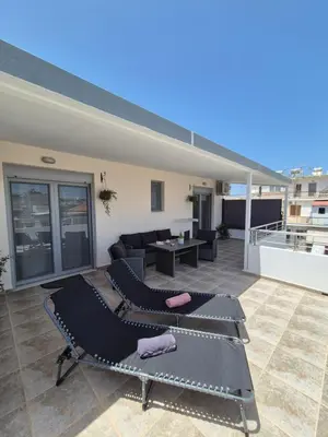 a patio with a couch and a table on a roof at Idene Penthouse in Chania Town