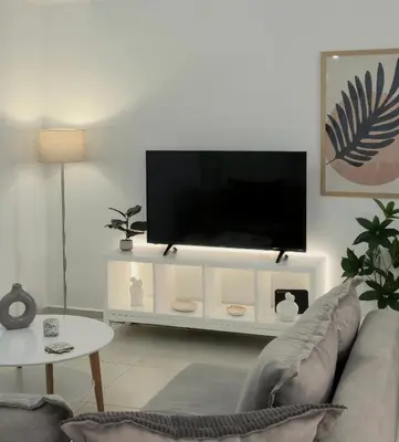 a living room with a flat screen tv on a white entertainment center at Idene Penthouse in Chania Town