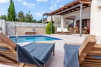 a villa with a swimming pool and patio furniture at Vila Vasiliki, Next To Platanias, 6min From Sea in Vrísai