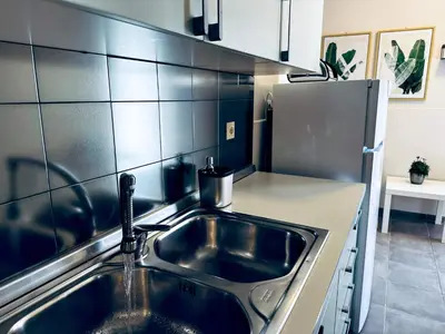 a kitchen with a sink and a refrigerator at lifeguard beachfront - Luxury Flat, 30meters From Sea in Stalos