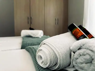 a room with two beds with towels on them at lifeguard beachfront - Luxury Flat, 30meters From Sea in Stalos