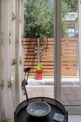 a table and a chair in front of a window at The Garden of Zephyrus - Halepa in Chania Town