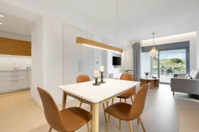 a kitchen and dining room with a white table and chairs at Le Mont Blanc - with shared Pool in Kounoupidhianá