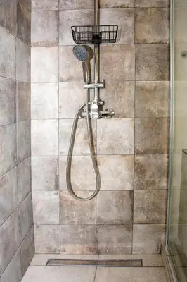 a shower with a shower head in a bathroom at Sia's Sea House in Almirida