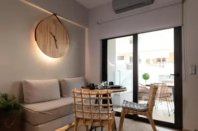 a living room with a couch and a clock on the wall at Anassa Seaside Residence- 50m from Sandy Beach in Chania Town