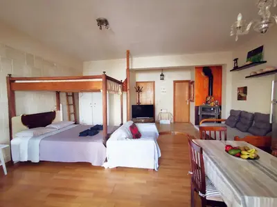 a bedroom with two beds and a living room at Sweet Home Leo in Chania Town