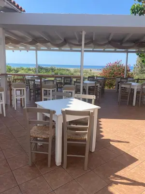 a white table and chairs on a patio at Artemis Hotel-MeRaki Restaurant in Frangokastello