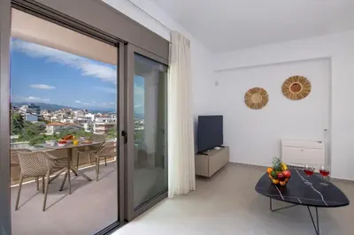 a living room with a balcony with a table and a television at A Heaven View Park Hideaway - Chania Nest in Chania Town