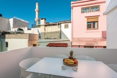 a table and chairs on a balcony with a bowl of fruit at On Luxury Chania in Chania Town