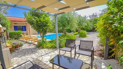 a patio with chairs and a table and a pool at Lemon Tree Villa with Private Pool and Starlink Internet in Frés