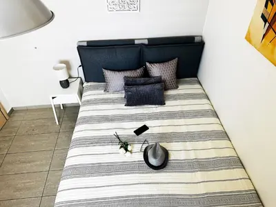 a bedroom with a bed with a black and white blanket at Cozy Snuggle- 2min To Beach, 6min Walk To Old Town in Chania Town