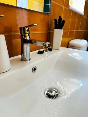 a sink with water coming out of a faucet at Cozy Snuggle- 2min To Beach, 6min Walk To Old Town in Chania Town